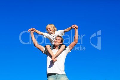 Youth sitting on his father's shoulders