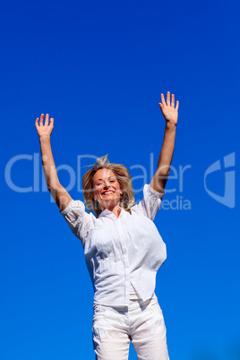 Carefree woman enjoying life against blue sky