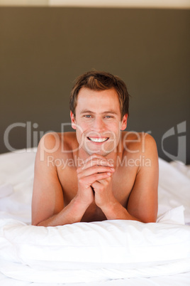 Smiling handsome boy lying in bed with copy-space
