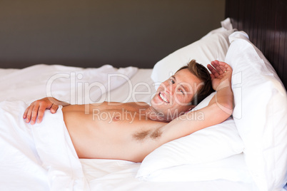 Smiling boy lying in bed