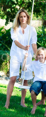 Mother and son swinging in a park
