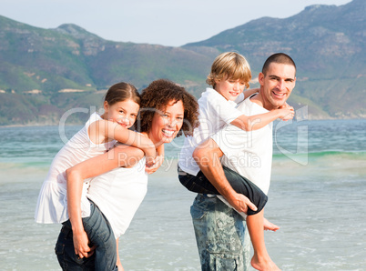 Parents giving two young children piggyback rides