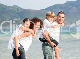 Parents giving two young children piggyback rides