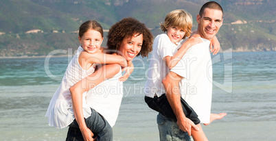 Parents giving two young children piggyback rides