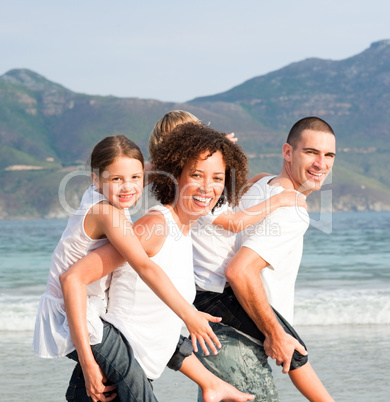 Parents giving two young children piggyback rides