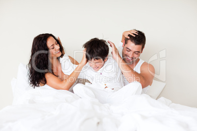 Couple and son playing in bed