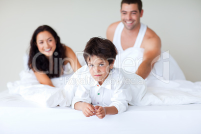 Couple and son enjoying together in bed