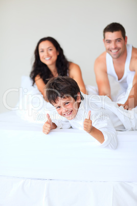 Son with thumbs up playing in bed