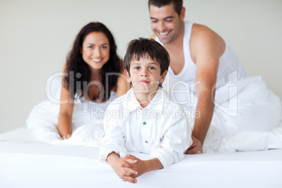 Young couple and son playing in bed