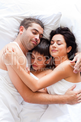 Couple and son sleeping in bed