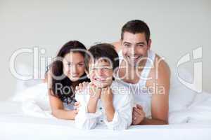 Happy family on bed with thumbs up