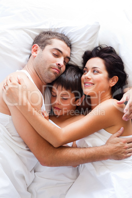 Happy family resting in bed