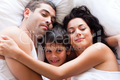Portrait of a happy family sleeping in bed