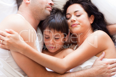 Portrait of a family sleeping in bed