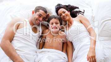 Family playing lying his son in bed