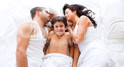 Smiling son with his parents sleeping