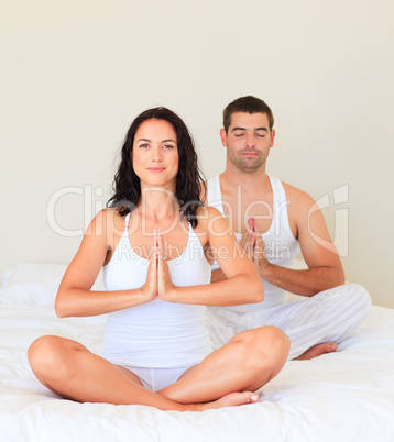 Couple doing yoga in bed