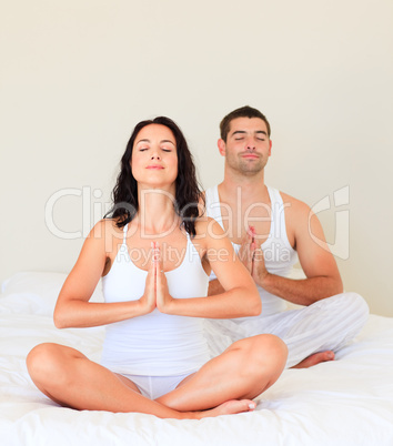 Couple doing yoga in bed