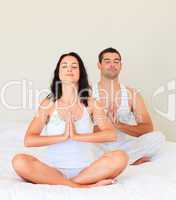Couple doing yoga in bed