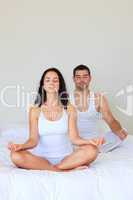 Couple meditating in bed