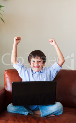 Happy child playing with his laptop