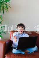 Kid using his laptop with thumb up