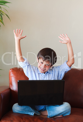 Happy child playing with his laptop