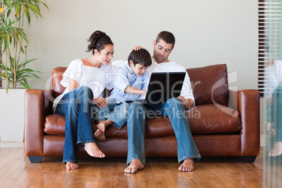 Parents and son playing with a laptop