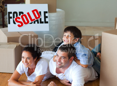 Family buying new house lying on floor