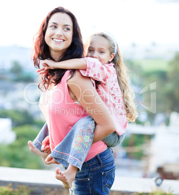 Mother giving daughter piggyback ride