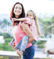 Mother giving daughter piggyback ride