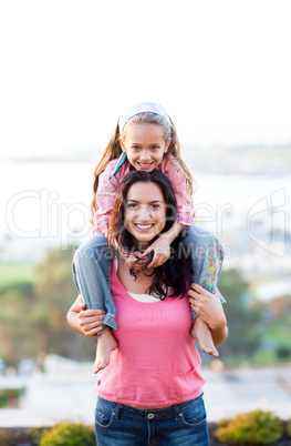 Mother giving daughter piggyback ride