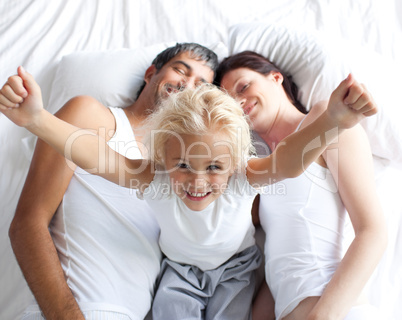 Happy little girl on bed with her parents