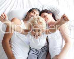 Happy little girl on bed with her parents