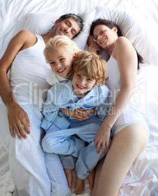 Happy parents and children together on bed