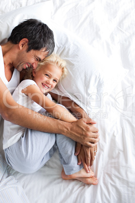 Father and daughter lying  on bed