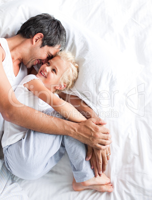 Father huggling her daughter on bed