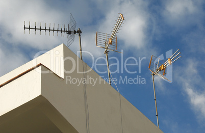 Drei Antennen auf einem Hausdach