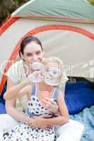 Mother and daughter blowing bubbles