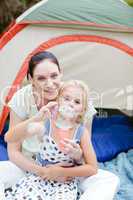 Mother and daughter blowing bubbles