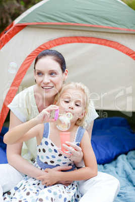 Mother and daughter having fun with bubbles