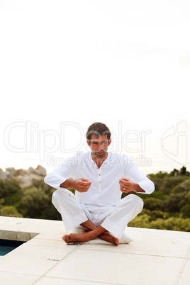 Man doing yoga on the pool with copy-space