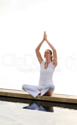 Woman doing yoga on the pool