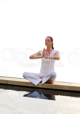 Woman doing yoga near the sea