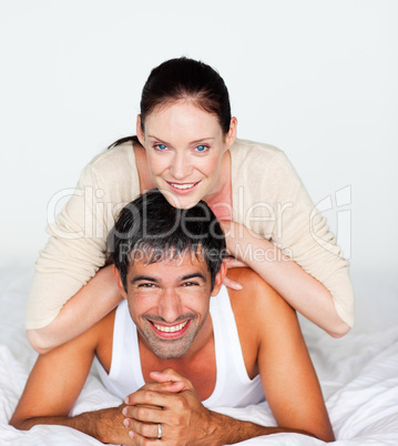 Couple having fun in bed looking at the camera