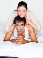 Father and mother playing in bed