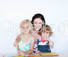 Children doing homework with their mother with thumbs up