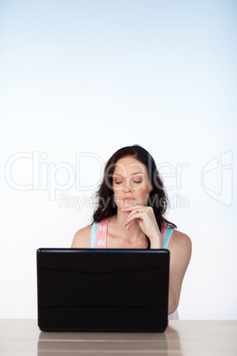 Serious woman working with her laptop with copy-space
