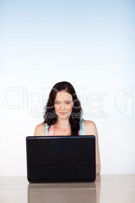 Serious woman focused on her laptop with copy-space