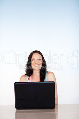 Smiling girl using a laptop with copy-space